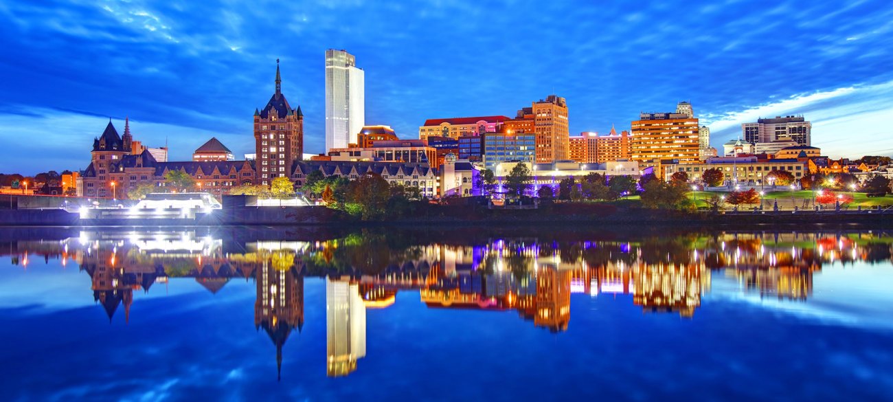 Skyline from river at night in Albany JetBlue Vacations package