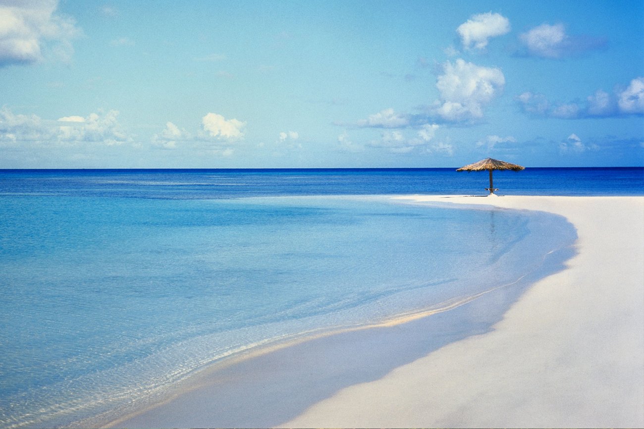 Aerial view of beach and sea in Jumby Bay, Antigua on a Caribbean Flight + Hotel Vacation Package