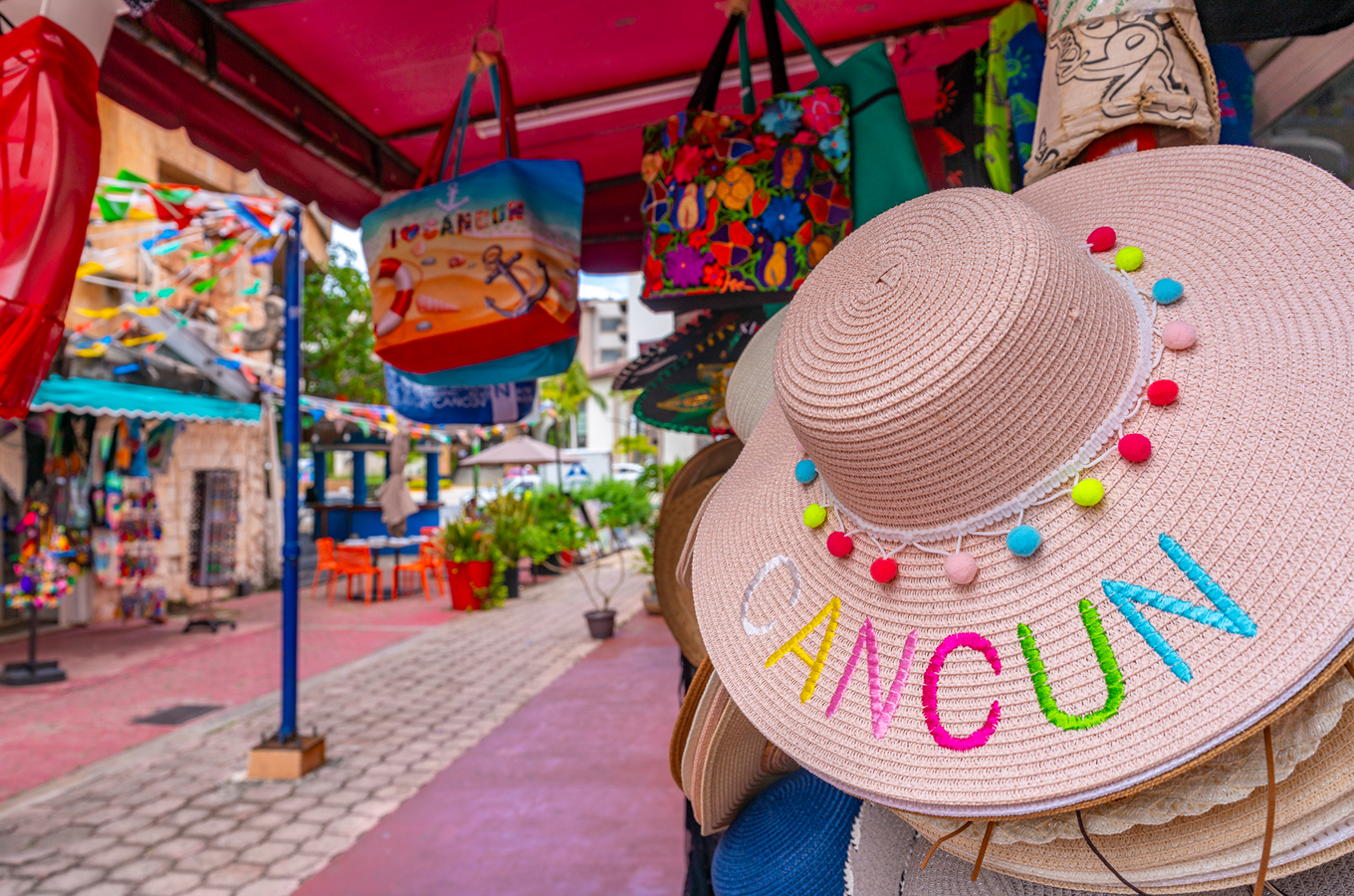 Vibrant downtown Cancún pedestrian street lined with souvenir stalls and colorful banners