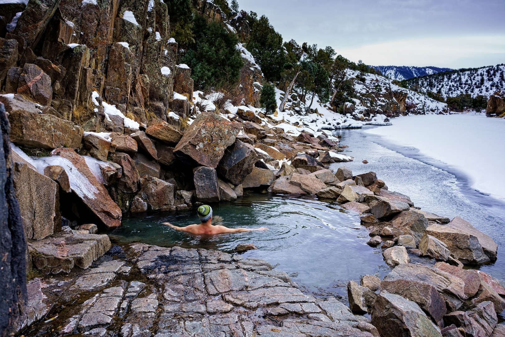 View of man in hot springs in Steamboat Springs on a JetBlue Vacations Flight + Hotel all inclusive package
