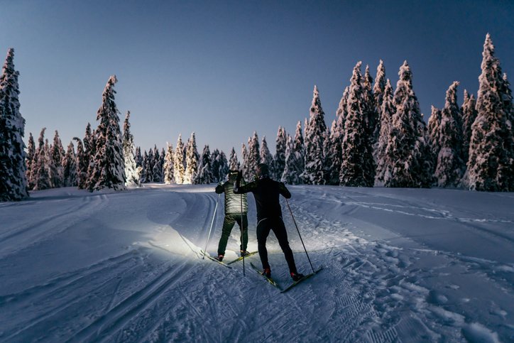 View of couple skiing in evening in Steamboat Spring, CO on a Flight + Hotel vacation package