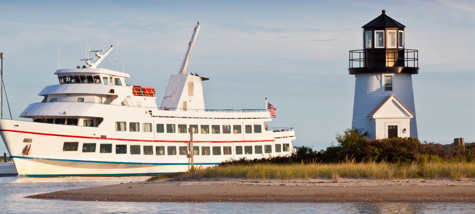 View of lighthouse and boat on a Hyannis, Massachusetts Flight + Hotel all inclusive JetBlue Vacations package
