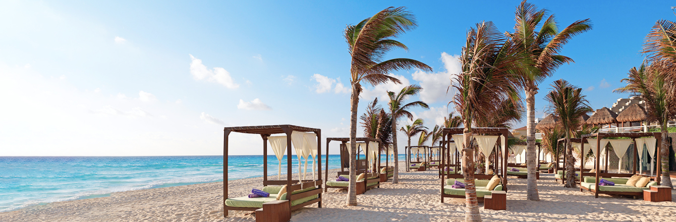 Beach cabana and palm trees on tropical beach with JetBlue Vacations and Marcus Pay