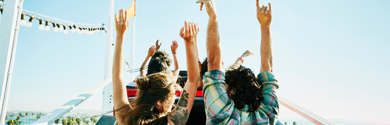 People riding roller coaster with hands up on an Orlando JetBlue Vacations all inclusive package