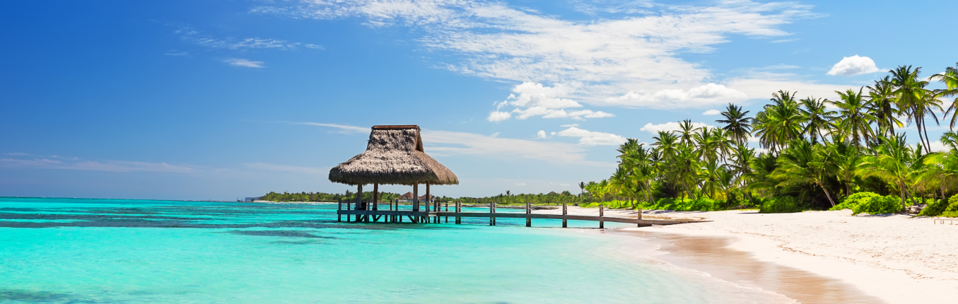 View of overwater gazebo on beach with trees on a JetBlue Vacations all inclusive package to Mexico