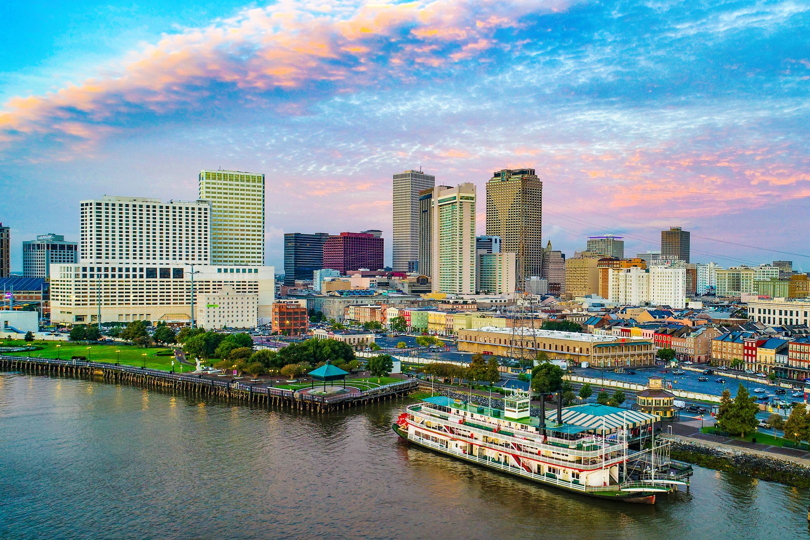 Aerial view of boats and city on Mississippi River in New Orleans on a Flight + Hotel vacation package