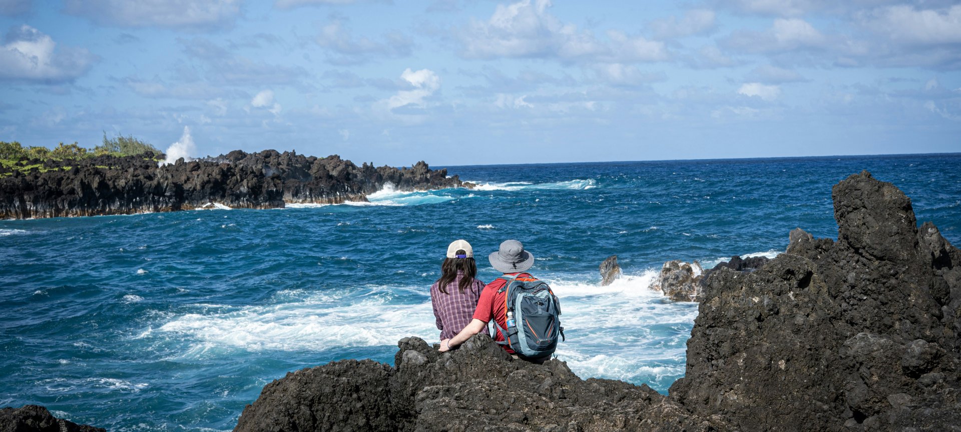 Couple sitting in rocks near Road to Kona, Maui, Hawaii