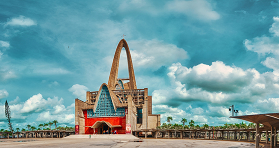 Front façade of the Basilica of Our Lady of Altagracia in Higüey, Dominican Republic, featuring its distinctive twin concrete arch spires