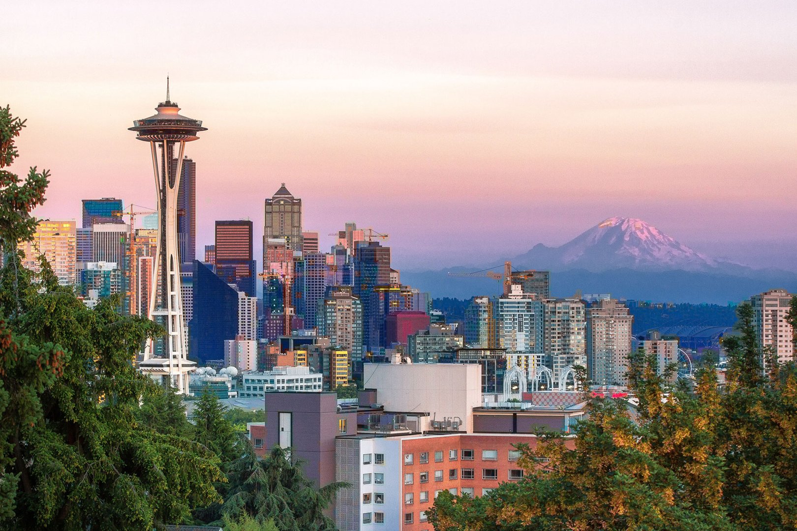 Aerial view of Seattle with Space Needle and Mt. Rainier at sunset on a JetBlue Vacations Seattle Flight + Hotel package