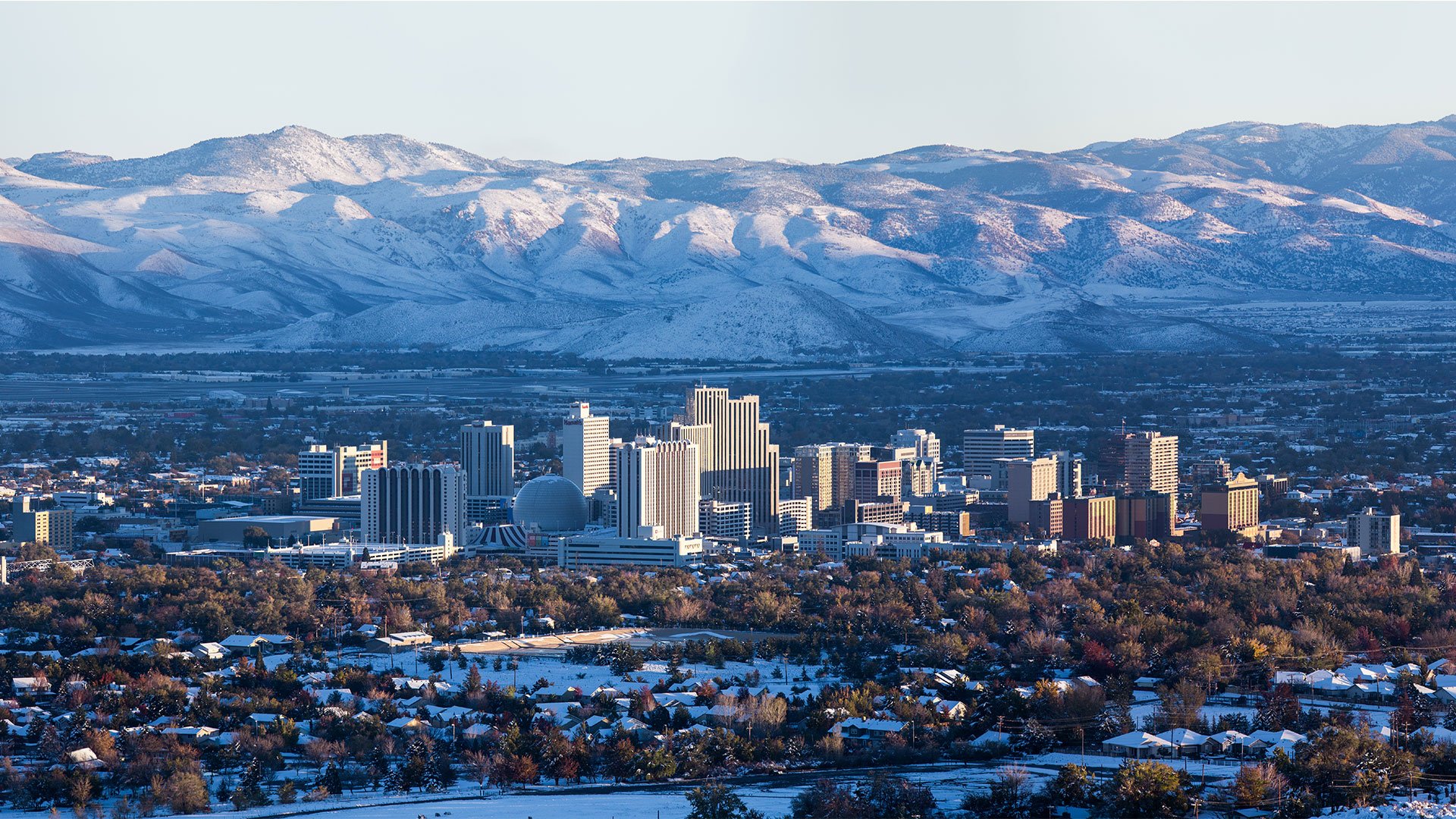 Aerial view of Reno skyline with mountains in distance on a Nevada Flight + Hotel JetBlue Vacations package