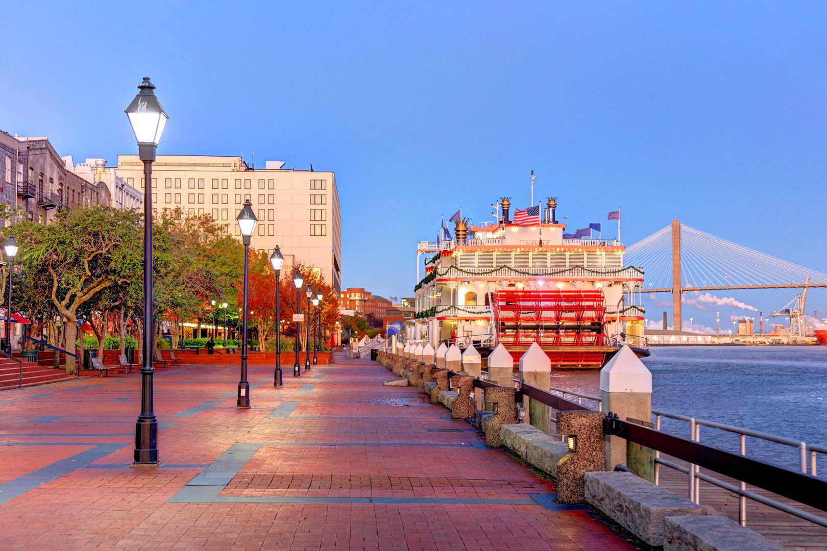 View of paddle wheeler and boardwalk at sunset on River Street in Savannah on a Georgia Flight + Hotel vacation package