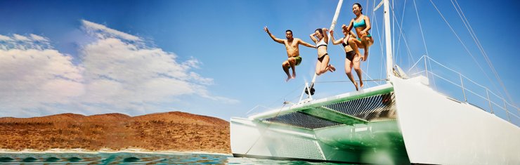 Family jumping off catamaran on a JetBlue Vacations package Travel Deal Reveal when booking within two weeks of travel