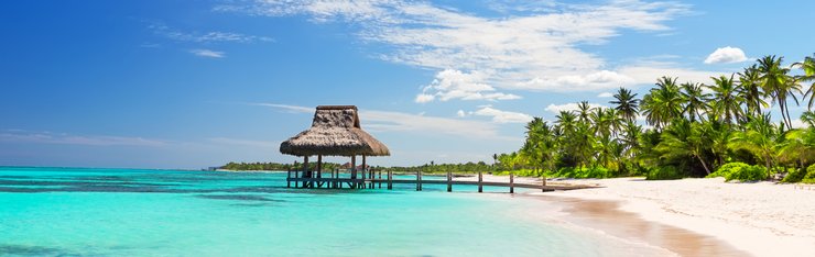 View of overwater gazebo on beach with trees on a JetBlue Vacations all inclusive package to Mexico